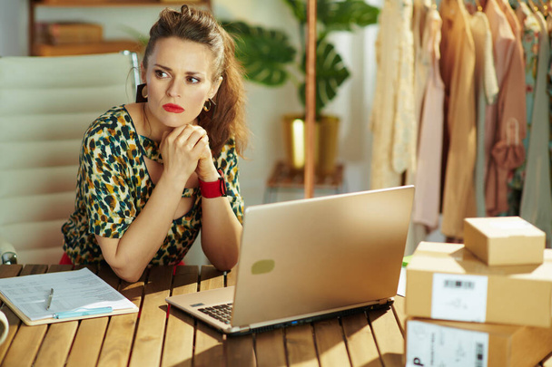 pensive young small business owner woman with laptop in the office. - Foto, Imagem