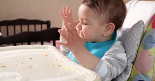 Mam voedt de jongen met een lepel en hand, familie eten en ouderschap concept. eerste aanvullende levensmiddelen en zelfvoeding - Video