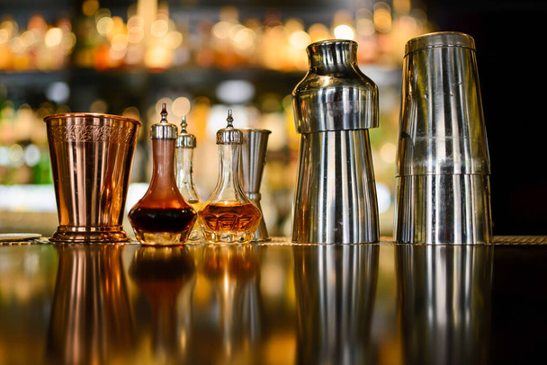 Ταλαντωτές και γυαλί χαλκού και bitters angostura στον πάγκο του μπαρ - Φωτογραφία, εικόνα