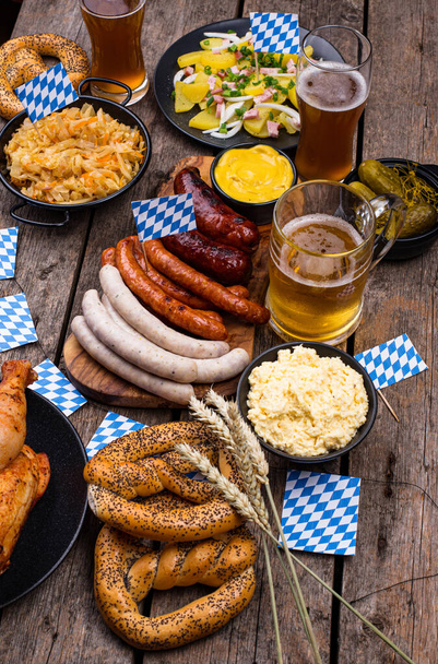 Oktoberfest dishes with beer, pretzel and sausage - Foto, afbeelding
