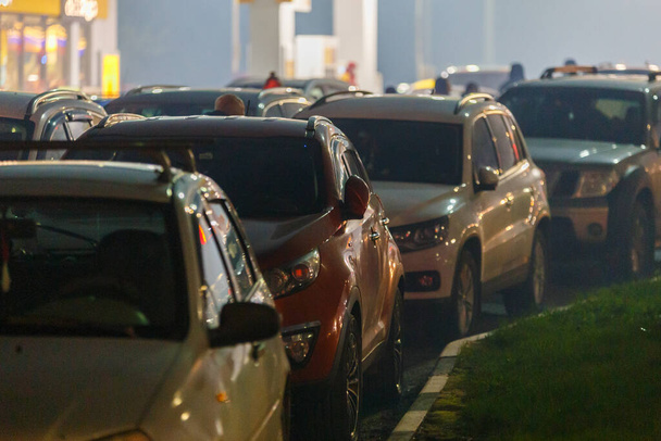 carros presos em engarrafamento no posto de gasolina na noite nebulosa durante a crise de fornecimento - Foto, Imagem