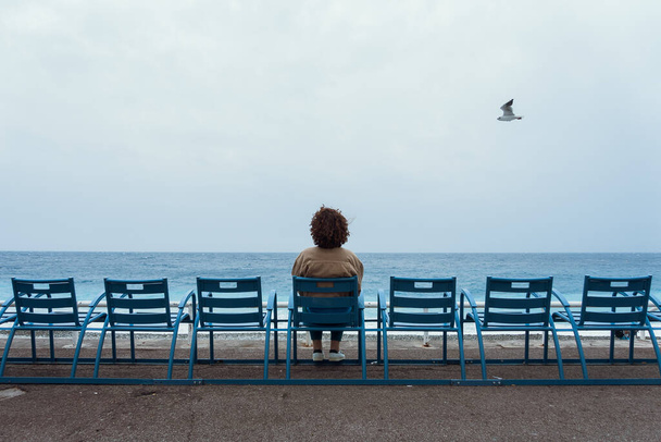 Γυναίκα κάθεται σε μπλε καρέκλες στη Νίκαια, Cote dAzur, Γαλλία - Φωτογραφία, εικόνα