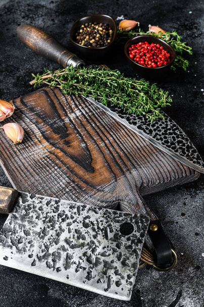 Cortadora de carne usada antigua y cuchillo con tabla de cortar de madera. Fondo negro. Vista superior - Foto, Imagen