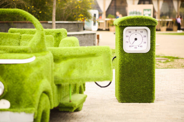 Зеленый травяной автомобиль и заправка. Охрана окружающей среды, поддержание чистого воздуха, заправка автомобилей биотопливом, экологически чистые. - Фото, изображение