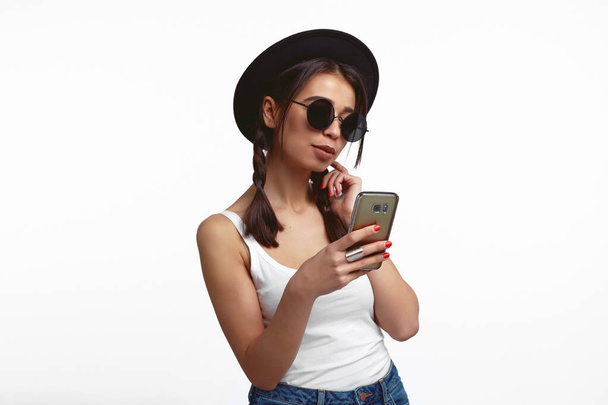 Tyttö katsoo näytön älypuhelimen nauttii verkossa chattailuun yli valkoinen seinä - Valokuva, kuva