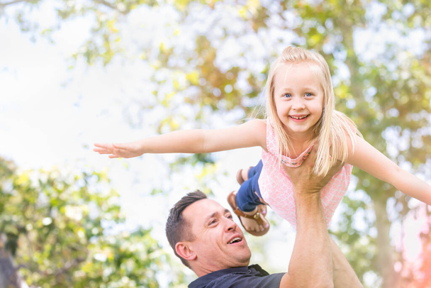 Молодий кавказьких батько і дочка веселяться в парку. - Фото, зображення
