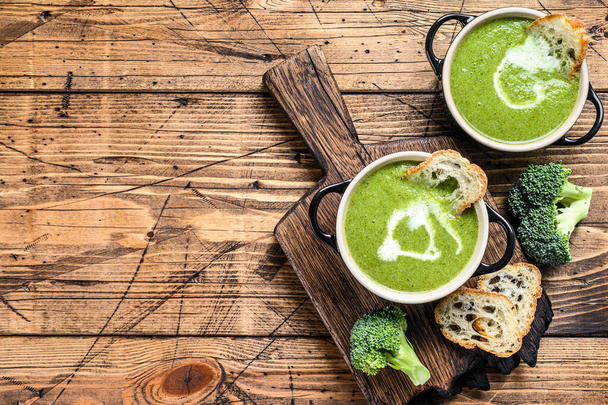 Homemade broccoli and spinach cream soup in bowl. Wooden background. Top view. Copy space - Foto, afbeelding