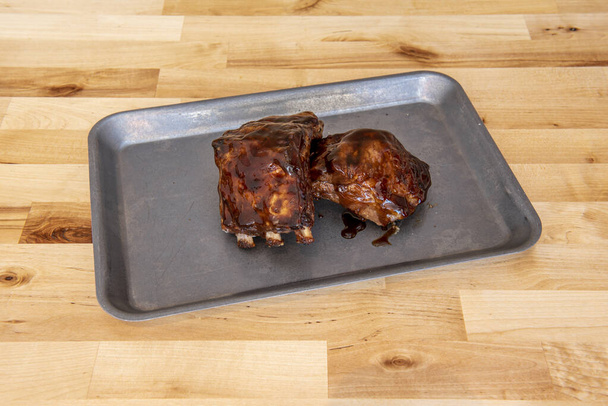 Herkullisia porsaankylkiluita marinoitu grillikastikkeella metallitarjottimella - Valokuva, kuva