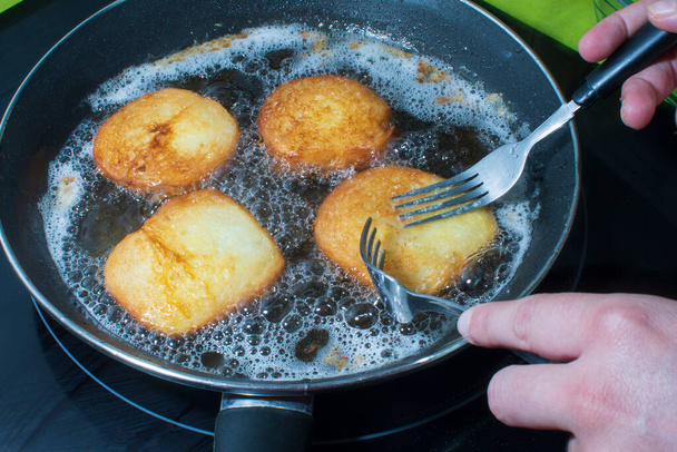 Cooking torrijas, a typical Spanish sweet fried toasts of sliced bread soaked in eggs and wine. Traditional dessert of Holy Week in Spain. - Photo, Image