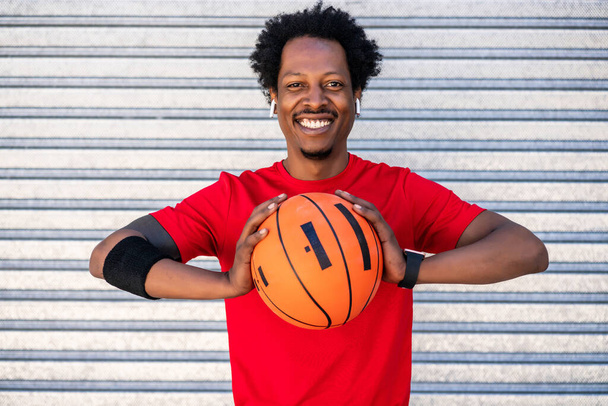 Afro athlete man holding a basketball ball outdoors. - Foto, afbeelding