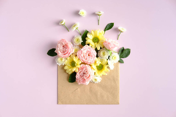 Open mail envelope with flowers on pink background. Romantic, Love letter, flowers delivery concept. - 写真・画像