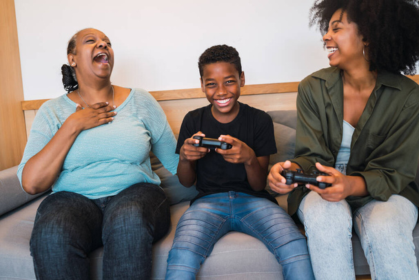 Grandmother, mother and son playing video games at home. - Foto, Imagem