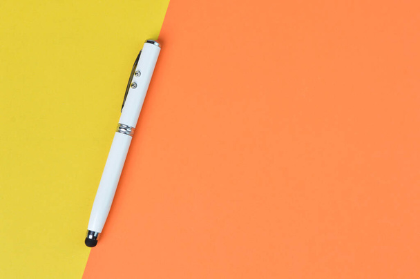 Vue du dessus du stylo blanc sur fond jaune et orange avec espace de copie. Concept d'entreprise - Photo, image