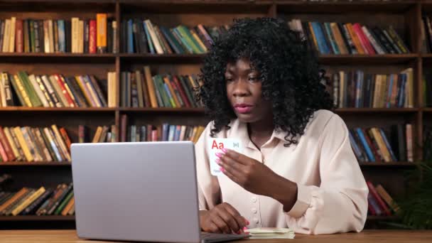 Afroamerykańska nauczycielka pokazuje karty z literami na ekranie - Materiał filmowy, wideo