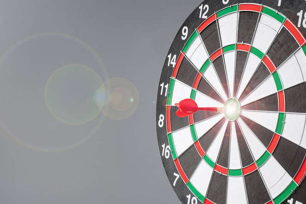 Red dart hitting a target on center of Bullseye or Dartboard. Business, competition, goal, success and marketing concept - Fotografie, Obrázek