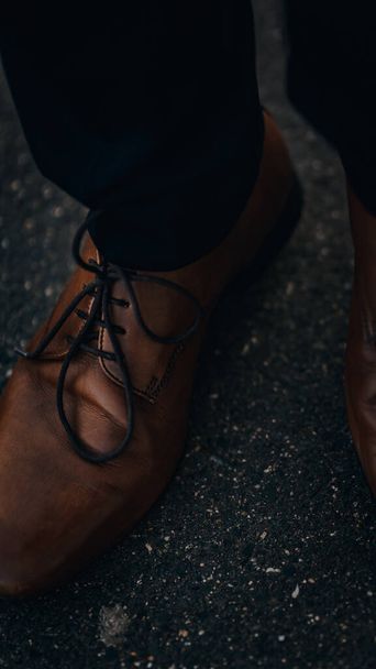 A vertical shot of a man wearing brown leather shoes - Fotoğraf, Görsel