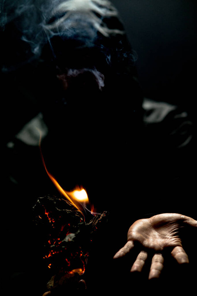 A vertical shot of a person holding a fire torch in the dark - Foto, Imagem