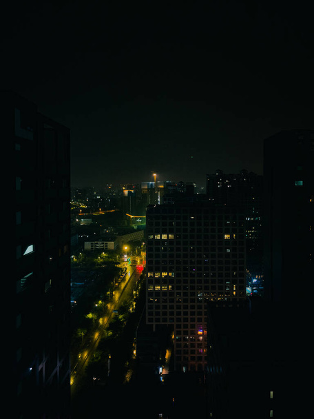 A beautiful view of a cityscape with illuminated tall buildings - Фото, изображение