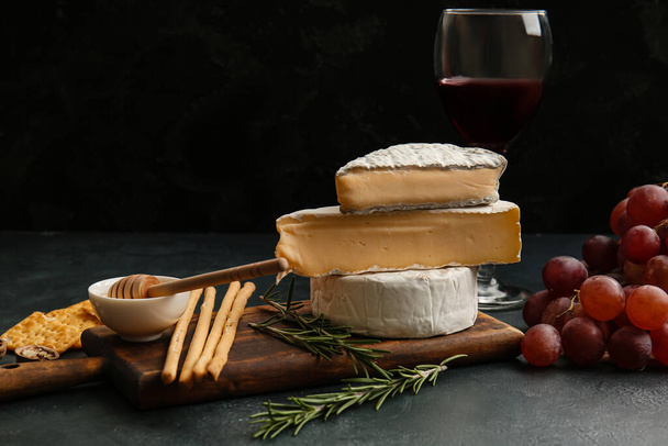 Szklanka wina, sera i przekąsek na ciemnym tle - Zdjęcie, obraz