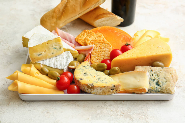 Tray with different types of cheese and snacks on light background, closeup - Photo, Image