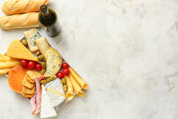 Different types of cheese, wine, bread and snacks on light background - Photo, Image