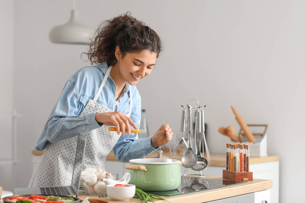 молодая женщина приготовление пищи на кухне - Фото, изображение