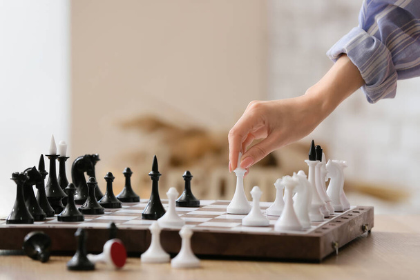 Woman playing chess on blurred background - Photo, Image