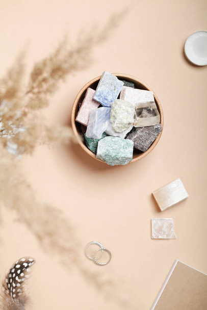 hierba de pampas, plumas y minerales cristalinos sobre fondo beige. roca mágica para ritual de cristal - Foto, imagen