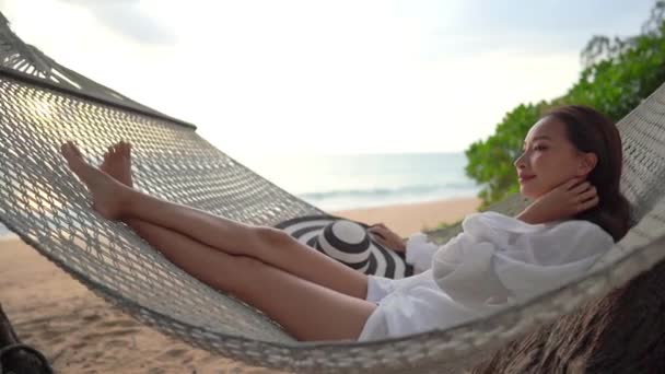 πλάνα από όμορφη Ασιάτισσα γυναίκα χαλαρώνοντας στην παραλία κατά τη διάρκεια των καλοκαιρινών διακοπών - Πλάνα, βίντεο