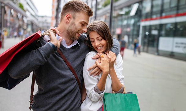 Beautiful young couple enjoying in shopping, having fun together. Consumerism, love, dating, lifestyle concept - Foto, afbeelding