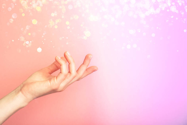 Hermosa mano femenina aislada sobre fondo de neón multicolor con desenfoque. Palma arriba, de cerca. Producto de alta resolución - Foto, imagen
