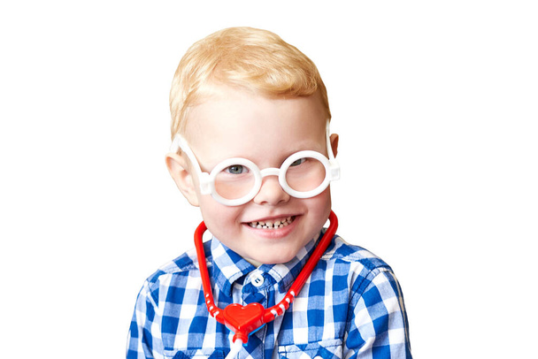 Beyaz arka planda izole edilmiş steteskopla oyuncak gözlük takan üç yaşındaki komik bir çocuğun portresi.. - Fotoğraf, Görsel