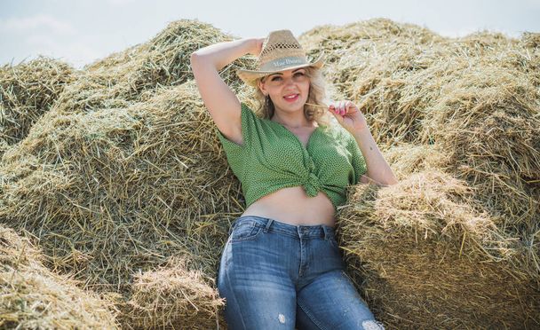 Plus size model in American country style at the hay. Concept of fashionable style and vogue - Фото, изображение