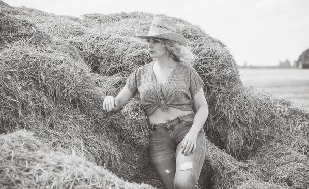 Plus size model in American country style at the hay. Concept of fashionable style and vogue - 写真・画像