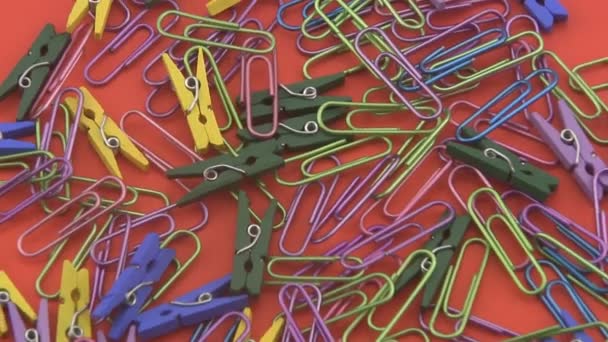Assorted coloured  paper clips rotating on a red background. - Footage, Video