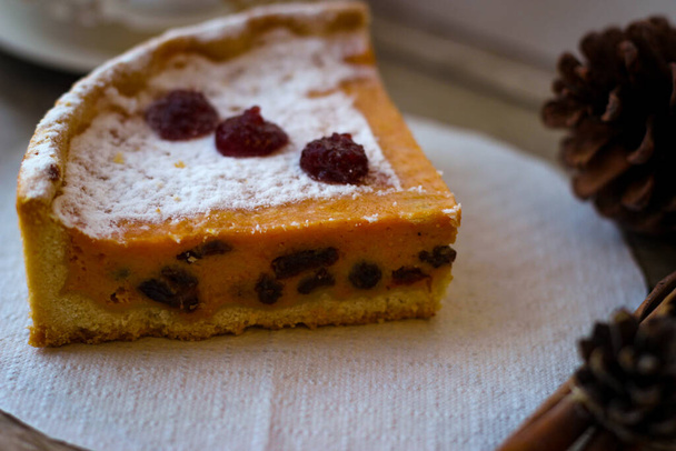 Шматочок солодкого пирога з сиру і гарбуза, посипаного зверху цукровою пудрою
 - Фото, зображення