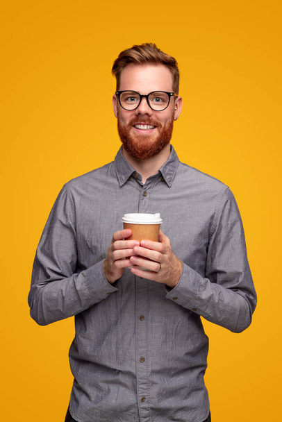 Smiling bearded man with takeaway coffee - Foto, afbeelding