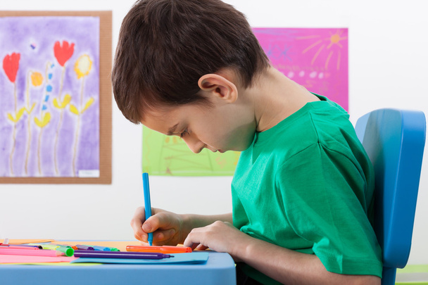 Boy paints something with markers at school - Photo, image