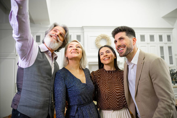 Lächelnde Familienmitglieder posieren bei Geburtstagsfeier für Selfie - Foto, Bild