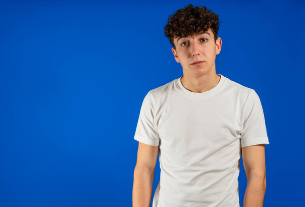 Portrait of attractive young man white curly hair posing on blue studio background. Fashion concept - Foto, immagini