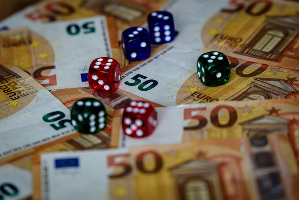 mehrere farbige Würfel und Euro-Geld für Glücksspielgewinne und Glücksspiele, die Sie reich und reich fühlen lassen - Foto, Bild