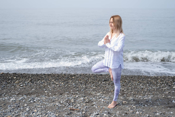 Mladé krásné ženy cvičí jógu na pláži. - Fotografie, Obrázek