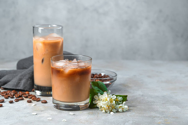 コーヒー豆と灰色の背景にミルクとアイスコーヒー。サイドビュー、コピースペース. - 写真・画像