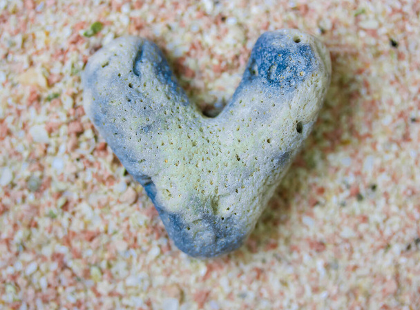 Pedra do mar em forma de coração cinza, rocha contra a areia rosa de verão flatly. Amor.. - Foto, Imagem