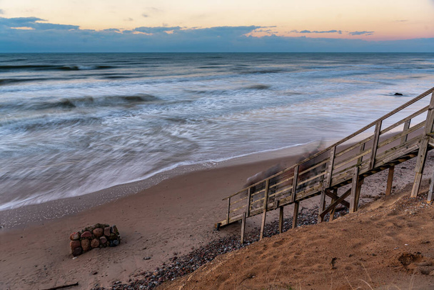 un escalier en bois qui vous permet d'atteindre le rivage de la plage très près du rivage de l'eau, tout comme d'aller directement dans l'eau de mer - Photo, image