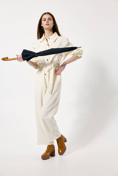 pretty woman white jumpsuit brown boots fashion rain umbrella - Valokuva, kuva