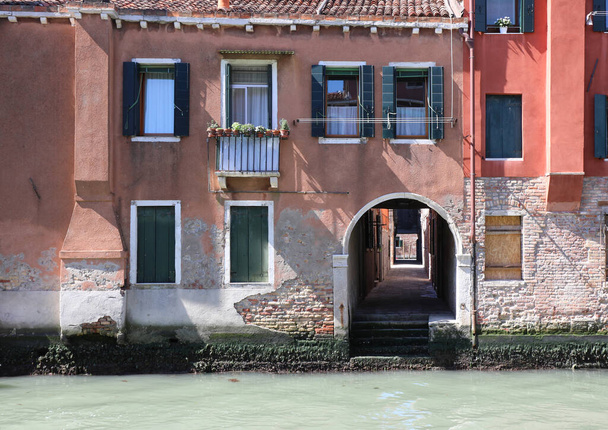 τυπικά βενετσιάνικα σπίτια με το κάνω στο πλωτό κανάλι είναι κάτω από βεράντα που οδηγεί σε άλλα μικρά στενά σοκάκια που ονομάζεται CALI στην ιταλική βενετική γλώσσα - Φωτογραφία, εικόνα