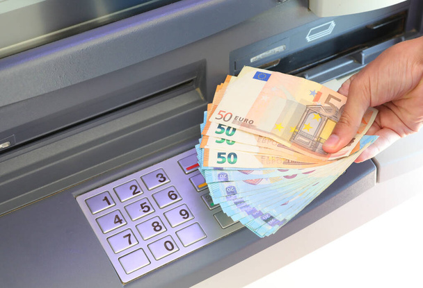 ATM makinesinden bir sürü para çekilen el ve PIN kodu yapmak için sayısal tuş takımındaki numaralar - Fotoğraf, Görsel