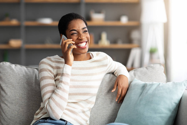 Portrét veselý afroameričanky mluví na mobilním telefonu doma - Fotografie, Obrázek