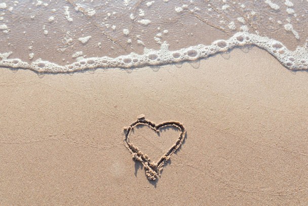 Jedno serce narysowane w piasku na plaży.Miękka fala morza.Prawdziwa romantyczna miłość. prawdziwa miłość. - Zdjęcie, obraz